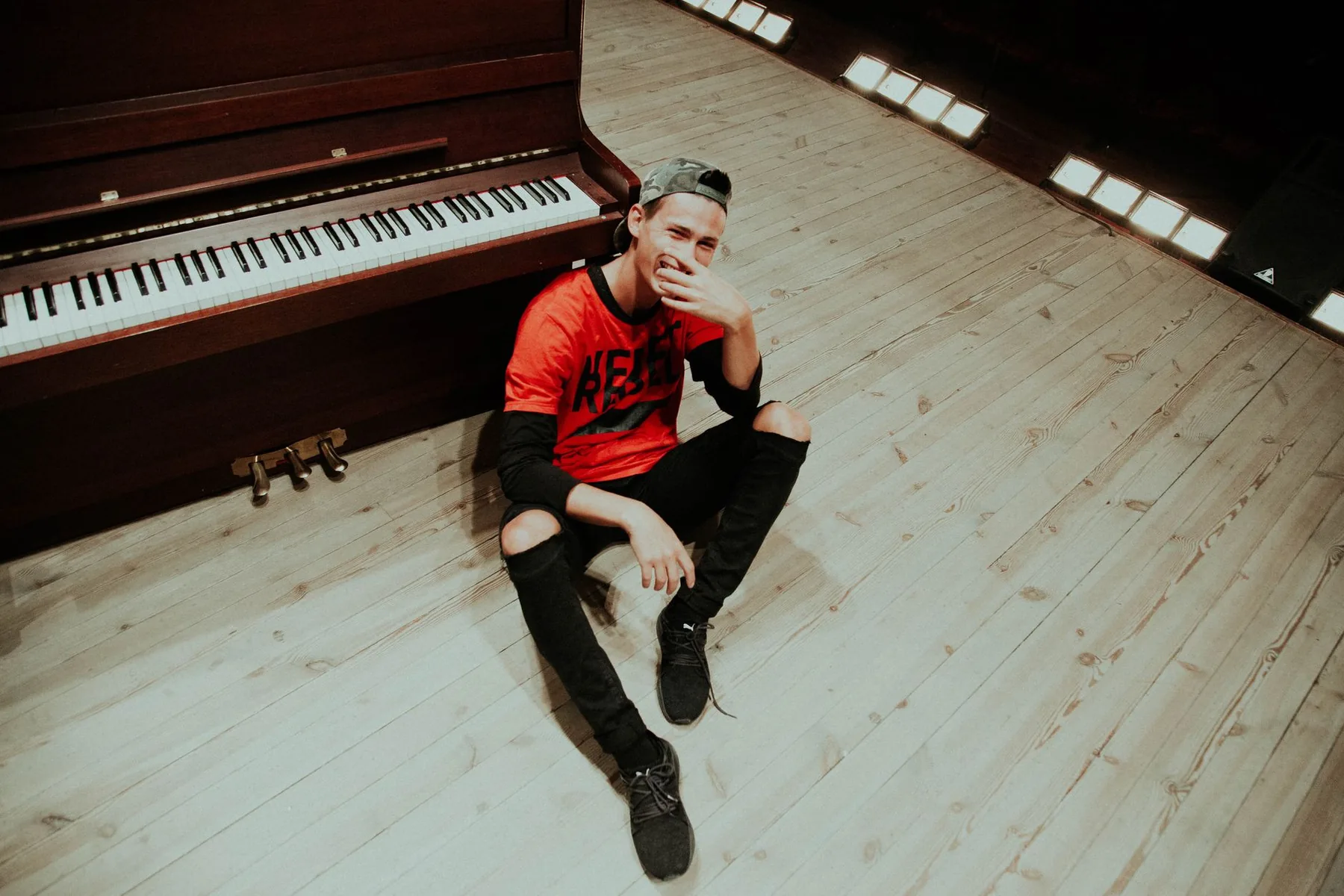 Man sitting near an upright piano Man sitting near an upright piano