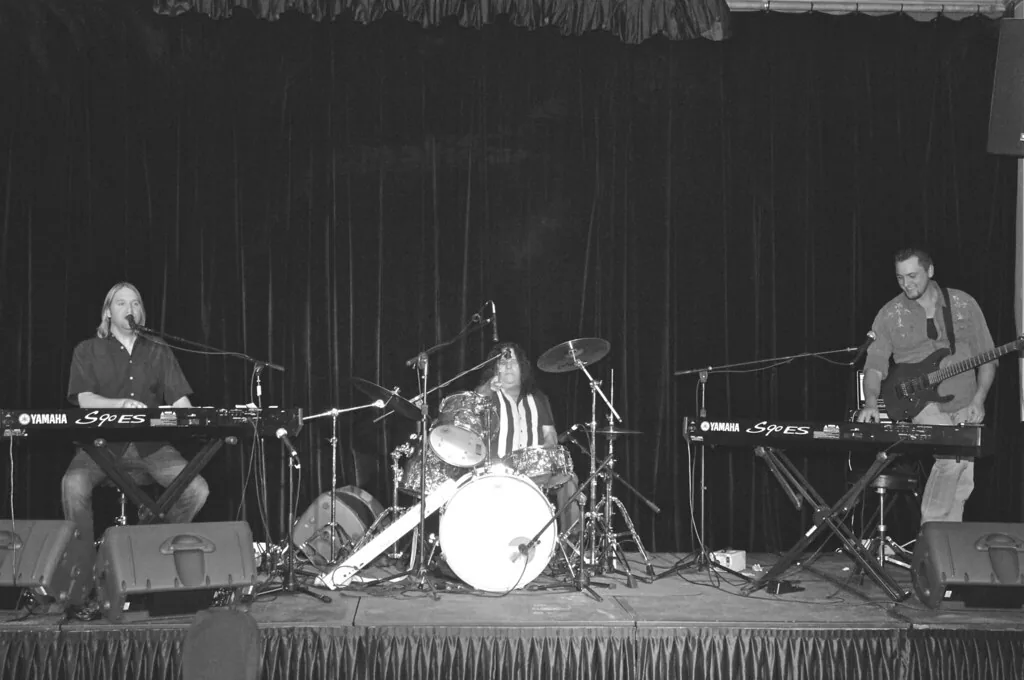 Musicians on stage with keyboards and drums
