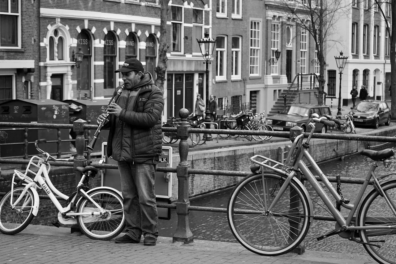 Musician playing the clarinet by the canal Musician playing the clarinet by the canal