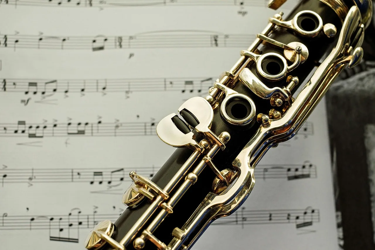 Close-up of a clarinet in front of sheet music Close-up of a clarinet in front of sheet music