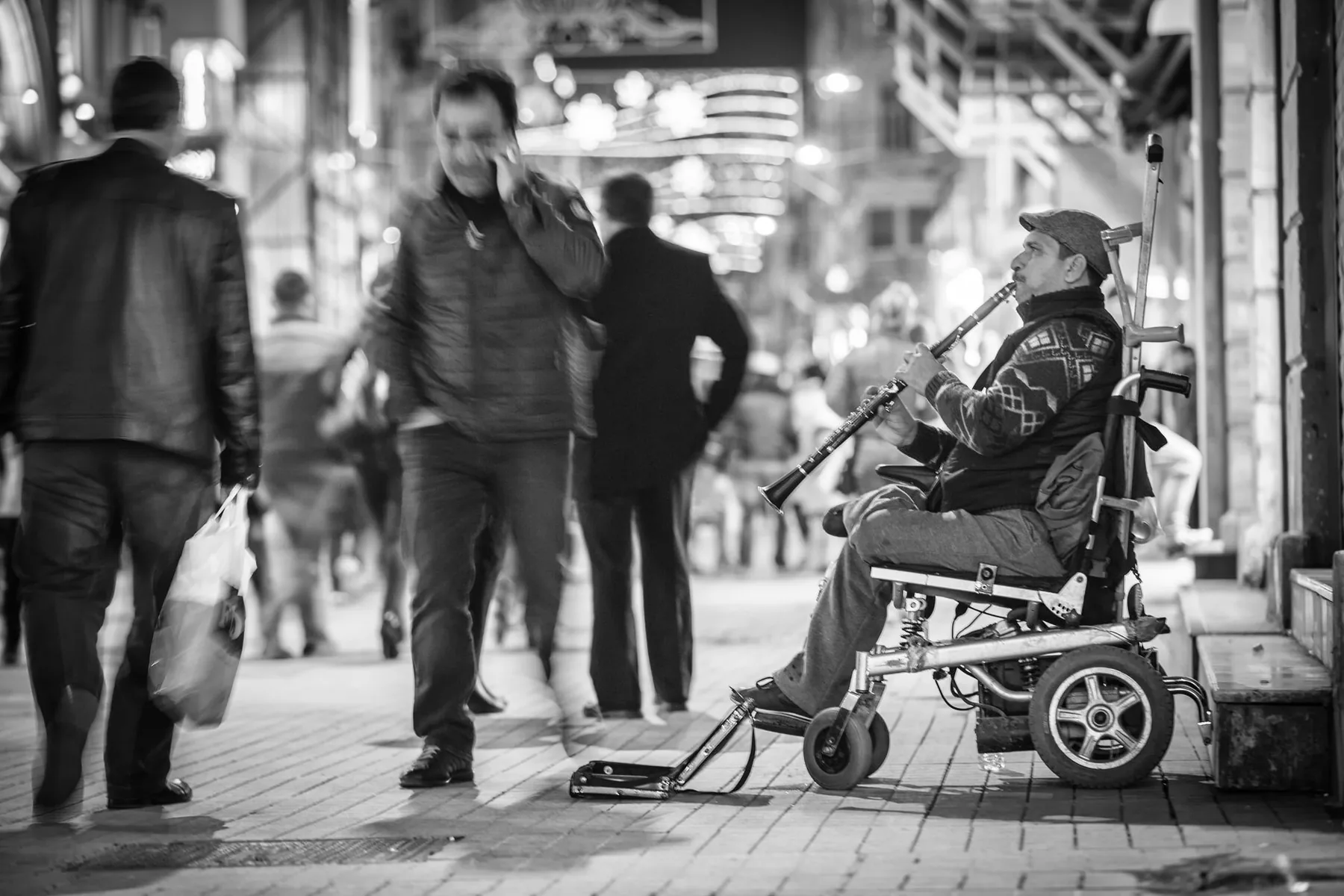 Clarinetist in a wheelchair on a busy street Clarinetist in a wheelchair on a busy street
