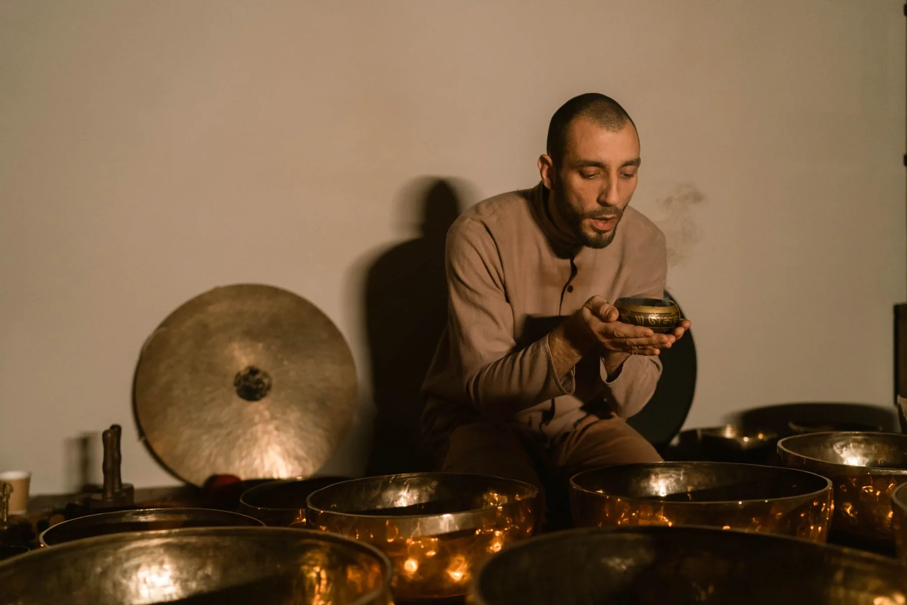 Man holding a Tibetan bowl among singing bowls Man holding a Tibetan bowl among singing bowls
