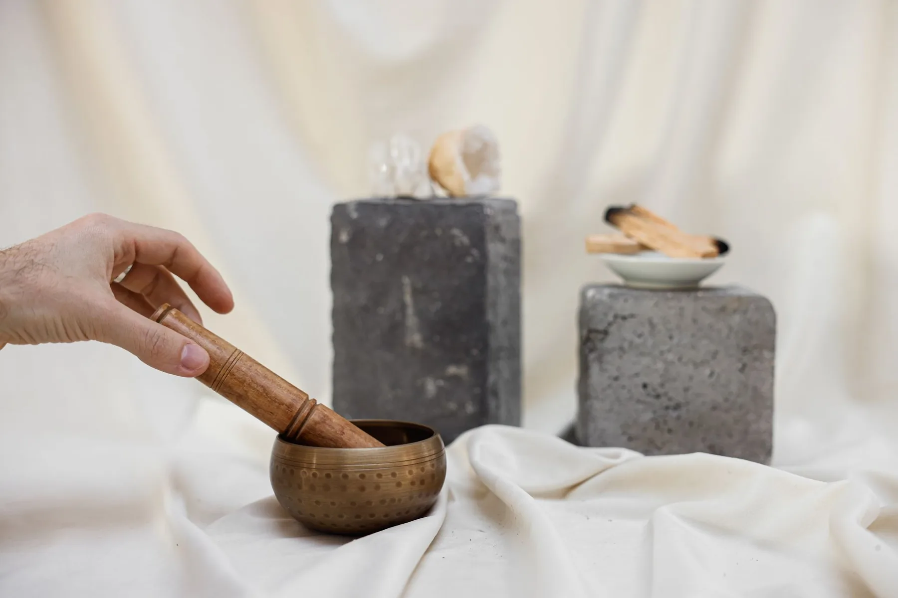 Hand holding a mallet in a Tibetan singing bowl Hand holding a mallet in a Tibetan singing bowl