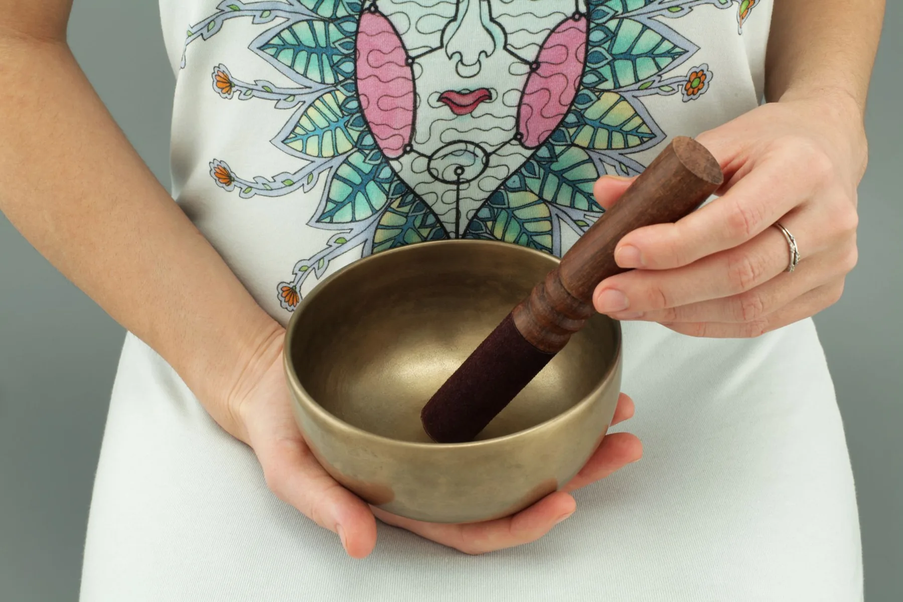 Tibetan singing bowl held in one hand with its mallet Tibetan singing bowl held in one hand with its mallet