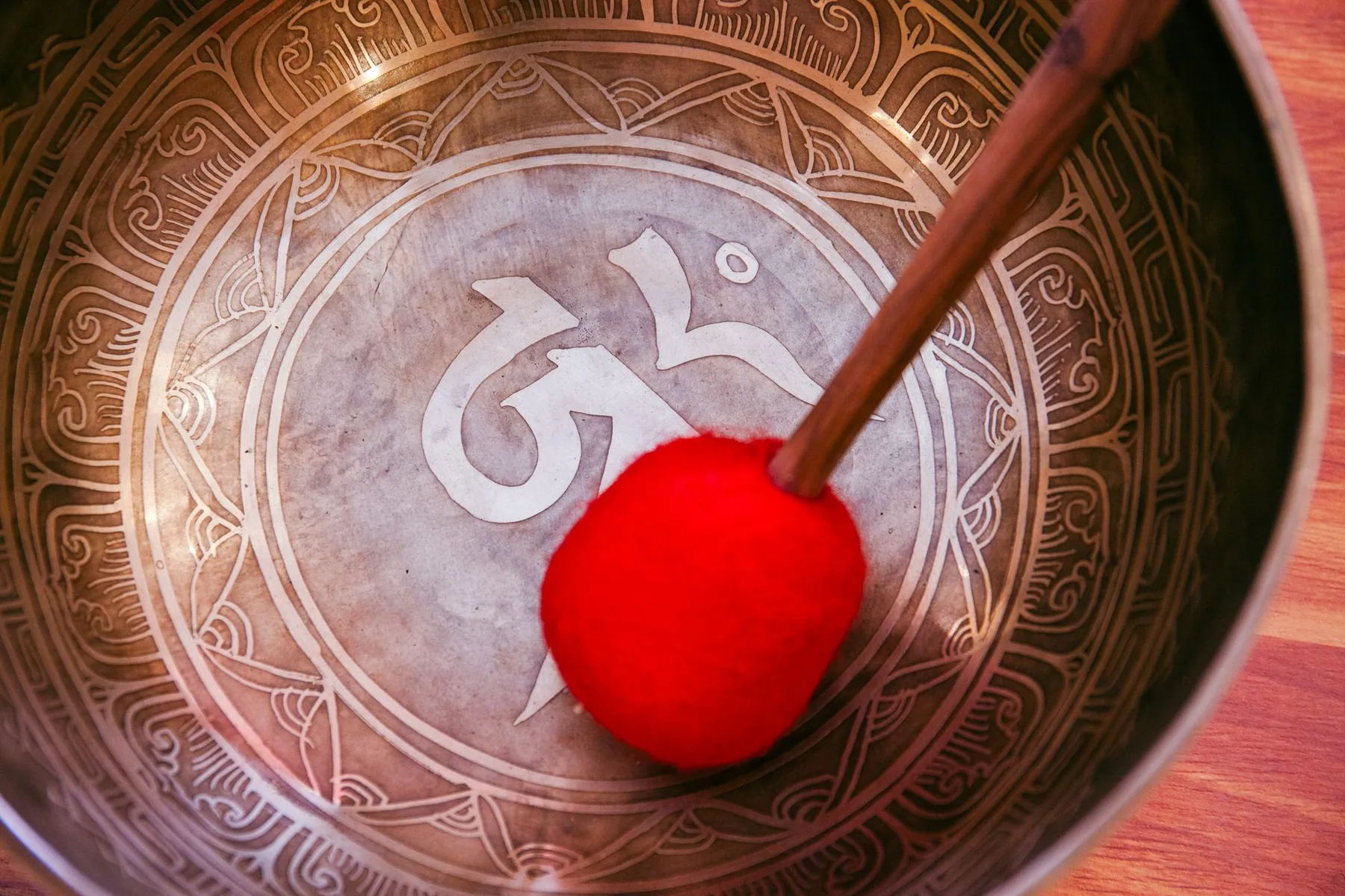 Engraved interior of a Tibetan singing bowl and red mallet Engraved interior of a Tibetan singing bowl and red mallet