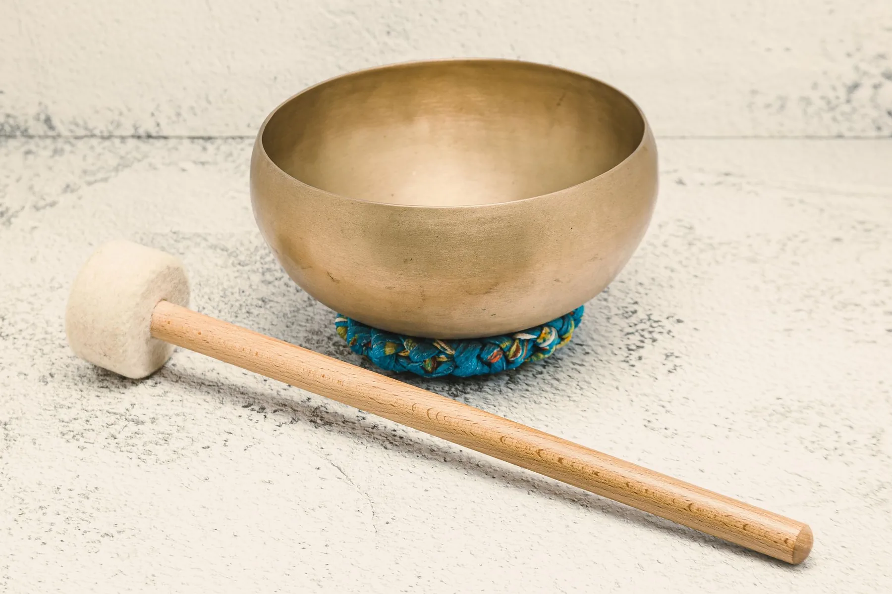 Tibetan singing bowl on a braided cushion with a mallet